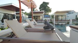 a house with a statue of a dog sitting on a patio at Pukawa Hotel & Residence in Chaloklum