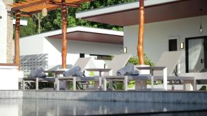 a group of chairs and tables in front of a building at Pukawa Hotel & Residence in Chaloklum