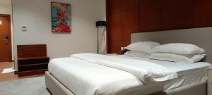 a bedroom with a large bed with white sheets and pillows at Al-TARABOT HOTEL in Muscat +1 photo