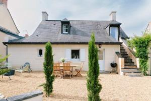 an exterior view of a house with a table and chairs at L'Antre quatre- 4p- Piscine partagée- Site troglodytique in Fontaine-Milon