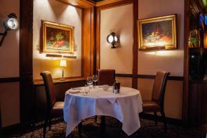 a dining room with a table and chairs and paintings at Hotel St.Gotthard in Zurich +58 photos