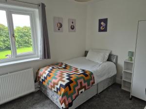 a small bedroom with a bed and a window at 2 double bedroom house 20mins walk to Durham city centre in Gilesgate
