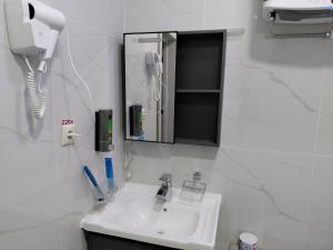 a bathroom with a sink and a mirror and a phone at FARIZ Hotel in Panjakent