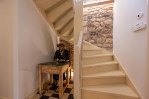 a staircase with a table and a statue of a man sitting at a desk at La Belle Hélène de Ménélas 1862 in Mykines