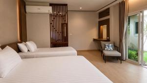 a hotel room with two beds and a chair at Phuket Airport Villa in Phuket +46 photos