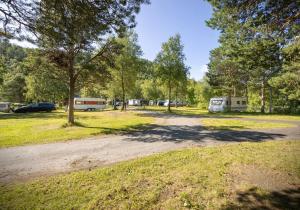 a dirt road in a park with tents and trees at Fauske Camping & Motel in Fauske