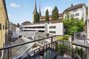 a balcony with a view of a building and a church at GLANDON Rooms Haldenhof - Self-Check-In in Lucerne