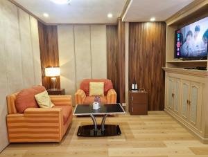 a living room with a couch and a table and a tv at The Canley Boutique Hotel Ortigas Pasig Metro Manila in Manila