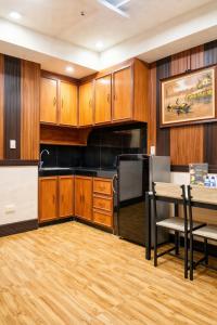 a kitchen with wooden cabinets and a table and chairs at The Canley Boutique Hotel Ortigas Pasig Metro Manila in Manila +70 photos
