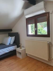 a bedroom with a bed and a window at Villa Napoleon Paris - Parking Gratuit - Accès Métro in Les Lilas