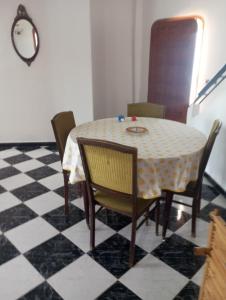 a dining room table with chairs and a checkered floor at Amsa aqua villa in Tétouan +10 photos