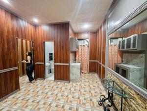 a woman standing in a room with a kitchen at The Canley Boutique Hotel Ortigas Pasig Metro Manila in Manila