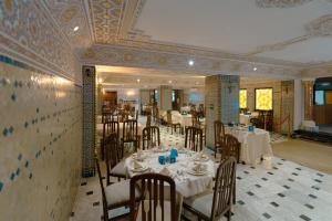 a restaurant with tables and chairs in a room at Hotel BouBabel in Nador