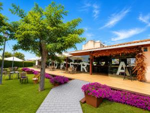 a patio with a tree and a building with purple flowers at Hotel Restaurante Plati in Villarcayo +8 photos