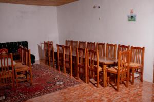 a dining room with a wooden table and chairs at Bujtina Mitaj in Vermosh