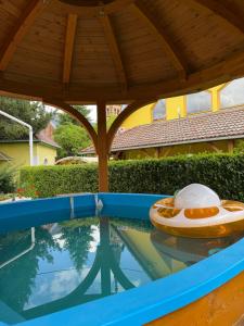 an outdoor swimming pool with a roof and a swimming poolvisor at Harang Panzió in Gyomaendrőd