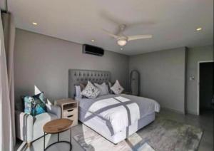 a bedroom with a white bed and a table at Apartment 24 in Durban