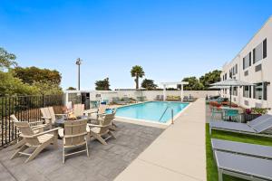 a pool with chairs and a table next to a building at Hampton Inn San Simeon Cambria in San Simeon