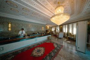 a man standing at a bar in a room with a red rug at Hotel BouBabel in Nador +103 photos