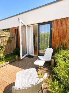 two white chairs and a table on a patio at Luxury Suites Oosterwold in Almere