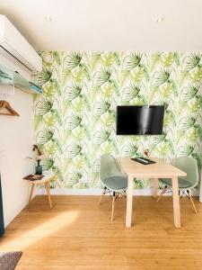a dining room with a tv and a table with chairs at Luxury Suites Oosterwold in Almere