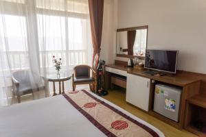a hotel room with a bed and a television and a table at Nhật Vy 1 Đà Lạt in Ấp Ða Lợi