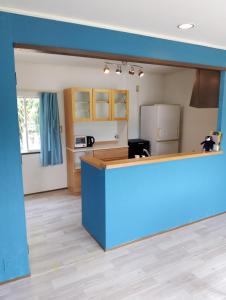 a kitchen with a blue counter in a room at ゲストハウス紗乃葉 - Suzunoha in Bōchū