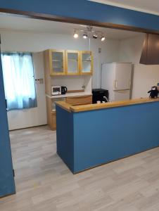 a kitchen with a blue counter and a refrigerator at ゲストハウス紗乃葉 - Suzunoha in Bōchū +61 photos