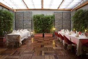 um restaurante com mesas brancas e plantas numa sala em Hotel Sporting Cologno em Cologno Monzese