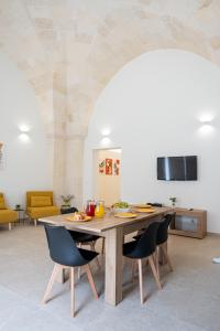 a kitchen with a table with chairs and a tv at Le Volte in Lizzano