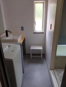 a small kitchen with a sink and a window at ゲストハウス紗乃葉 - Suzunoha in Bōchū