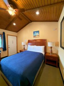 a bedroom with a blue bed with two night stands and two lamps at Atlantic Motel in Point Pleasant Beach +22 photos