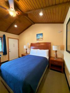 a bedroom with a blue bed with two night stands and two lamps at Atlantic Motel in Point Pleasant Beach