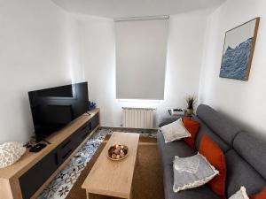 a living room with a couch and a tv at Carimar, a mirada da ría in Boiro