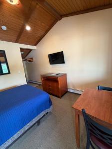 a bedroom with a bed and a tv and a table at Atlantic Motel in Point Pleasant Beach