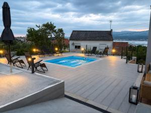 a patio with a pool and chairs and a house at Carimar, a mirada da ría in Boiro