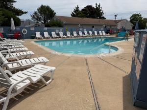 a swimming pool with lounge chairs and a swimming pool at Atlantic Motel in Point Pleasant Beach