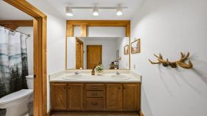 a bathroom with two sinks and a mirror at Hillside Hideaway in Sevierville +29 photos