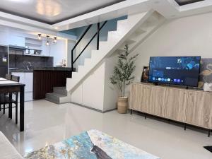 a living room with a tv and a staircase at Jabs cabin 2 in Angeles