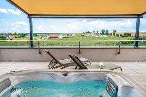 a bath tub in a room with a large window at Lazuli Apartment in Hegykő
