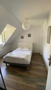 a bedroom with a white bed and a staircase at tyklan in Bénodet