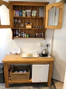 a kitchen with a counter with a sink and shelves at Samphire in Padstow