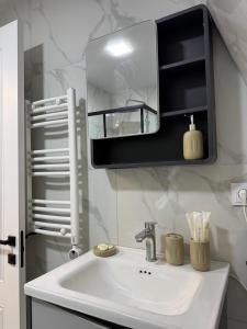 a bathroom sink with a mirror on the wall at CottageNEO in Charnali