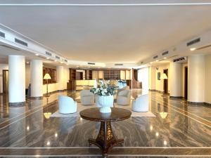 eine Lobby mit einer Blumenvase auf einem Tisch in der Unterkunft Naples Park Hotel in Marigliano