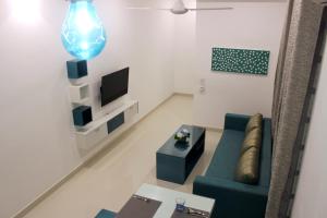 a living room with a green couch and a tv at Mount Princess in Mount Lavinia