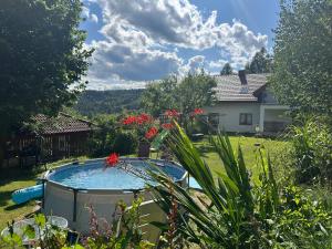 a backyard with a swimming pool and a house at Zakątek Słoneczny pod Baranią Górą in Kamesznica