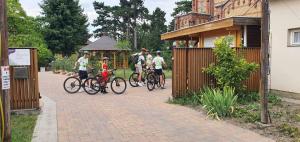 a group of people riding bikes down a driveway at Harang Panzió in Gyomaendrőd