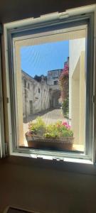 a window with a view of a building and flowers at La Corte dei Sogni in Taviano