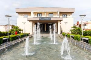 a building with a fountain in front of a building at Hotel La Costiera in Varcaturo