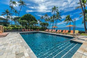 a swimming pool with chairs and umbrellas at a resort at WAILEA ELUA, #1104 in Wailea